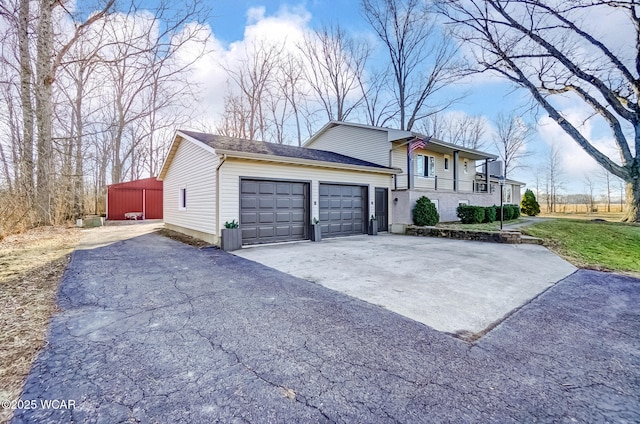 view of front of house with a garage, driveway, and a shingled roof