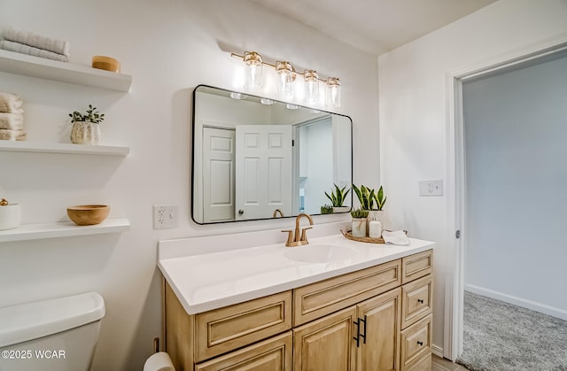 bathroom with baseboards, toilet, and vanity