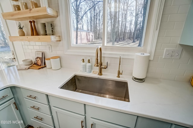 details featuring decorative backsplash, open shelves, and a sink