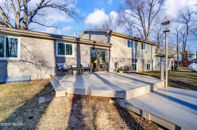 rear view of house with brick siding, central air condition unit, and a deck