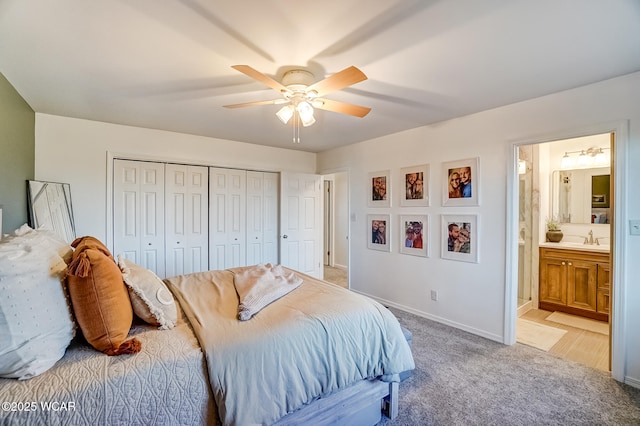 bedroom featuring connected bathroom, ceiling fan, light colored carpet, a closet, and a sink