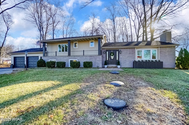 split level home featuring an attached garage, driveway, a chimney, and a front lawn