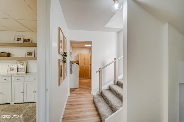 hall with stairs, light wood-style flooring, and baseboards