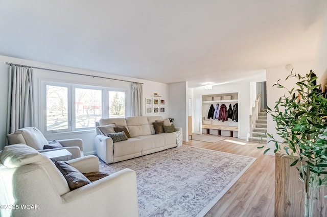 living area featuring light wood finished floors and stairway