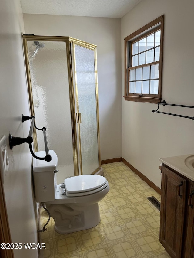 bathroom featuring walk in shower, vanity, toilet, and a textured ceiling