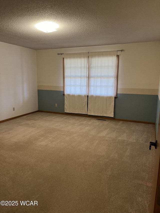 carpeted spare room with a textured ceiling