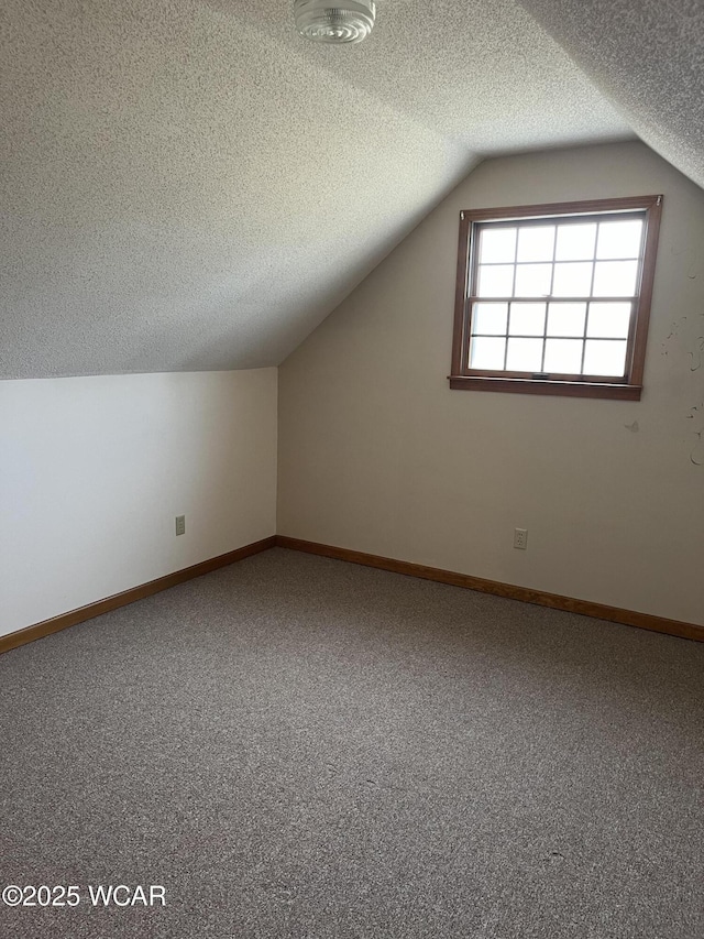 bonus room with carpet, lofted ceiling, and a textured ceiling