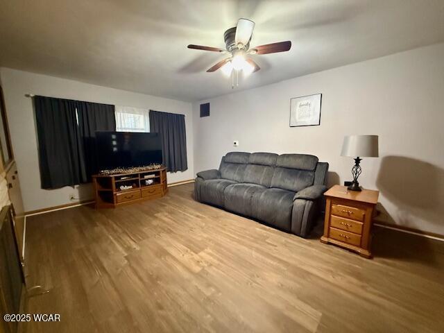 living area featuring visible vents, ceiling fan, and wood finished floors