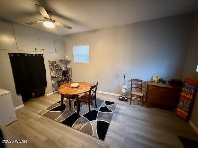 dining space with ceiling fan, light wood-type flooring, and baseboards