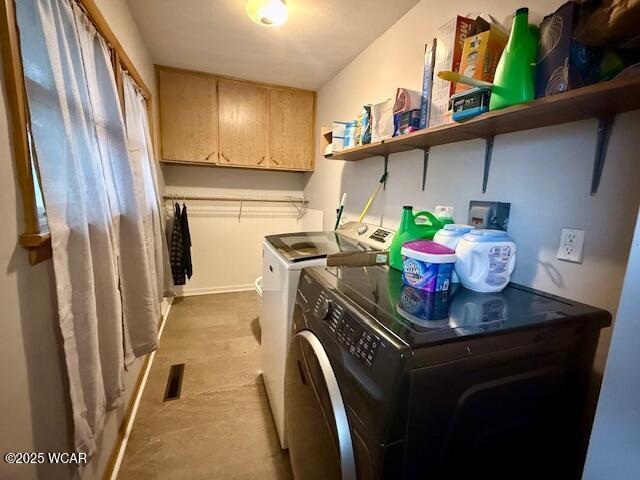 washroom featuring cabinet space, visible vents, and washing machine and clothes dryer