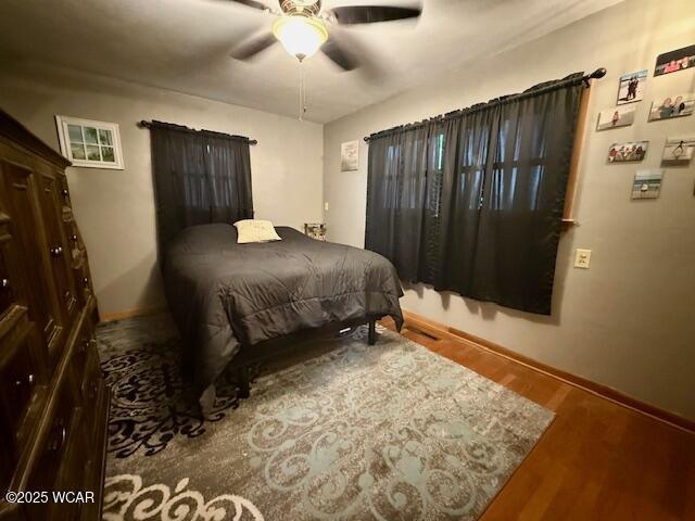 bedroom with baseboards, a ceiling fan, and wood finished floors