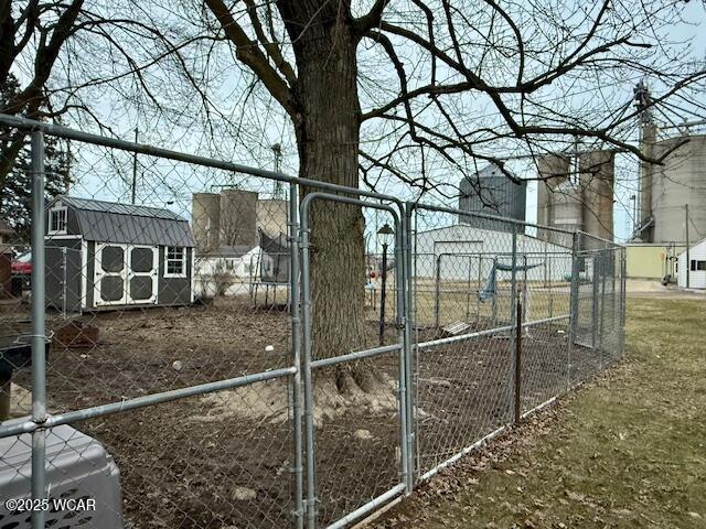 view of yard featuring an outbuilding, fence, and a shed