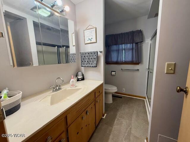 bathroom with toilet, a shower stall, baseboards, and vanity