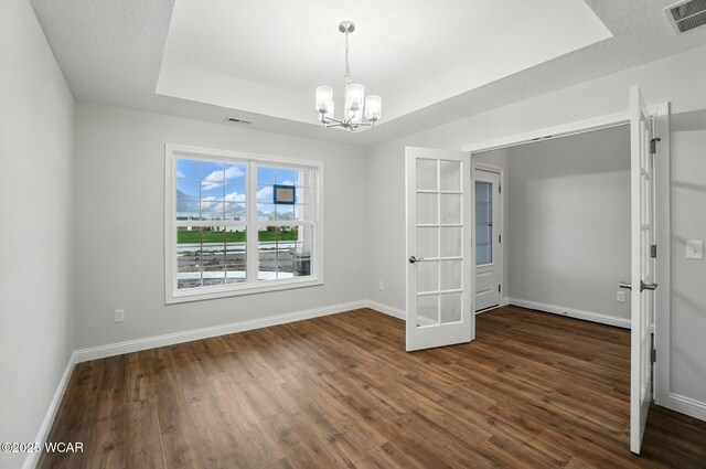 1291 Madison Blvd, Van Wert, OH 45891 - unfurnished room featuring a chandelier, french doors, dark wood-type flooring, a tray ceiling, and visible vents