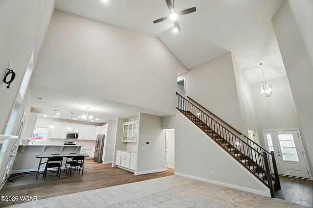 1291 Madison Blvd, Van Wert, OH 45891 - living room with high vaulted ceiling, ceiling fan with notable chandelier, stairs, and wood finished floors