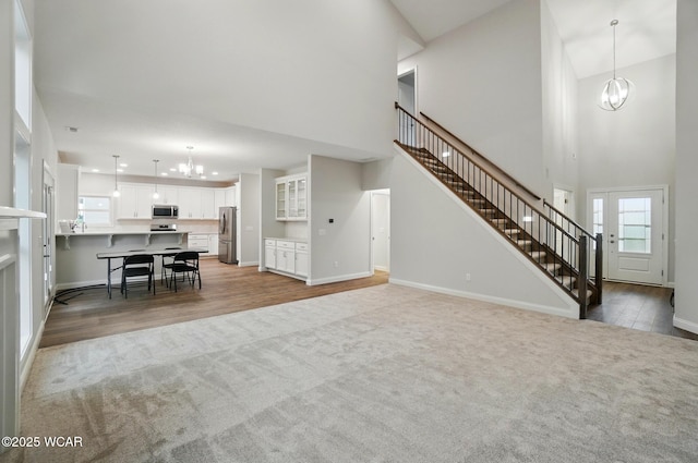 1291 Madison Blvd, Van Wert, OH 45891 - carpeted living room with baseboards, a towering ceiling, a notable chandelier, and stairway