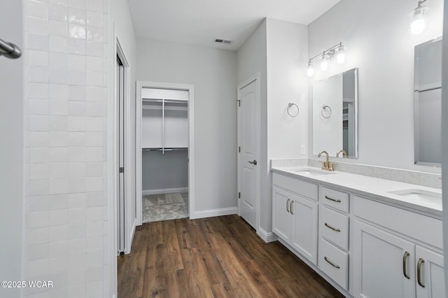 1291 Madison Blvd, Van Wert, OH 45891 - bathroom featuring visible vents, a sink, a spacious closet, and wood finished floors