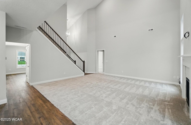 1291 Madison Blvd, Van Wert, OH 45891 - unfurnished living room with a towering ceiling, a fireplace, wood finished floors, baseboards, and stairs