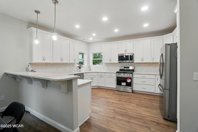 1291 Madison Blvd, Van Wert, OH 45891 - kitchen with appliances with stainless steel finishes, tasteful backsplash, a sink, a peninsula, and a kitchen bar