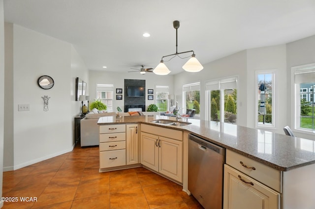 kitchen featuring ceiling fan, dishwasher, a sink, open floor plan, and cream cabinetry