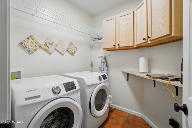 laundry room featuring cabinet space, separate washer and dryer, baseboards, and dark tile patterned flooring