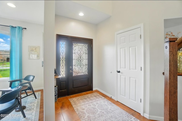 entrance foyer with recessed lighting, baseboards, a wealth of natural light, and tile patterned flooring