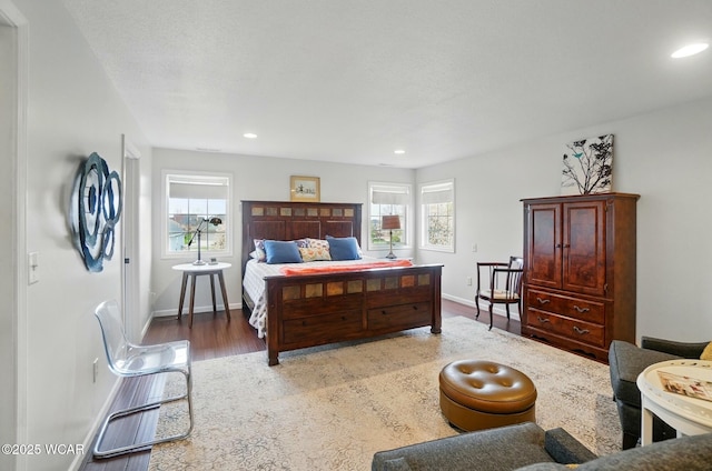 bedroom with baseboards, recessed lighting, wood finished floors, and multiple windows