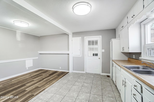 kitchen with white cabinetry, sink, and light tile patterned floors