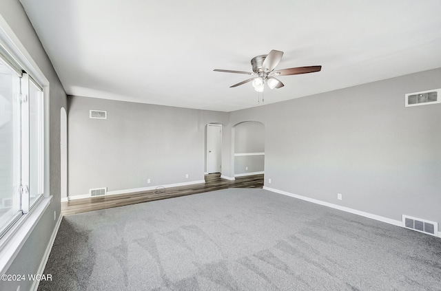 spare room featuring ceiling fan and dark carpet