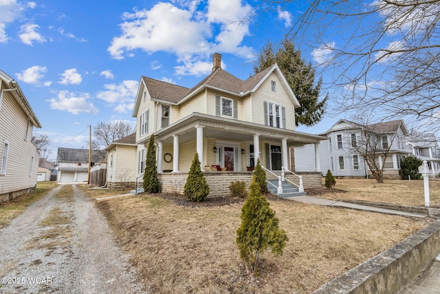 view of front of home featuring covered porch, roof with shingles, a chimney, and an outdoor structure