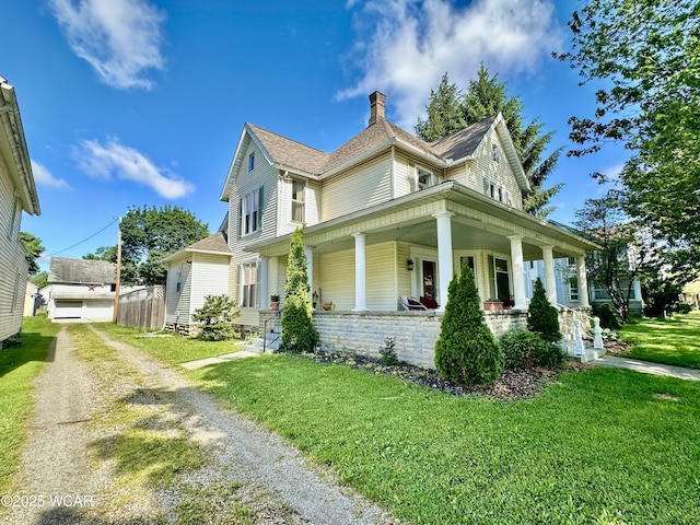 827 N Main St, Fostoria, OH 44830 - view of front of home with a porch, a front lawn, driveway, a chimney, and roof with shingles