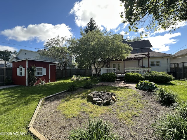 827 N Main St, Fostoria, OH 44830 - view of yard featuring a wooden deck, an outbuilding, and an outdoor fire pit