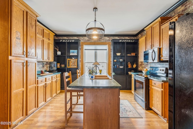 827 N Main St, Fostoria, OH 44830 - kitchen featuring stainless steel appliances, a sink, decorative backsplash, light wood-style floors, and crown molding
