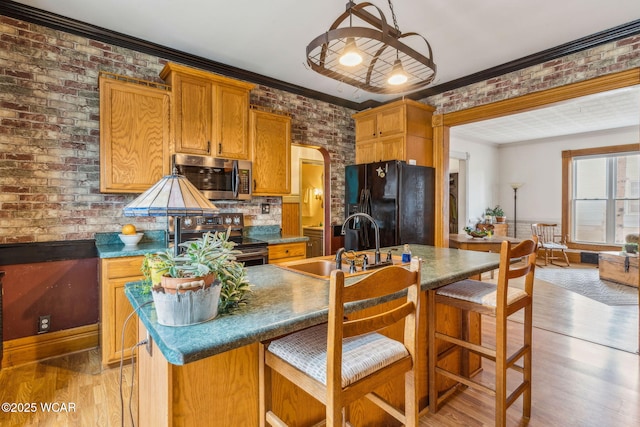 827 N Main St, Fostoria, OH 44830 - kitchen featuring appliances with stainless steel finishes, a sink, light wood-type flooring, crown molding, and a kitchen bar