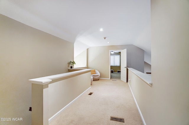 corridor featuring lofted ceiling and light colored carpet