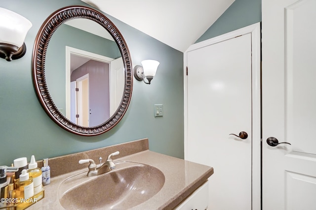 bathroom with lofted ceiling and vanity