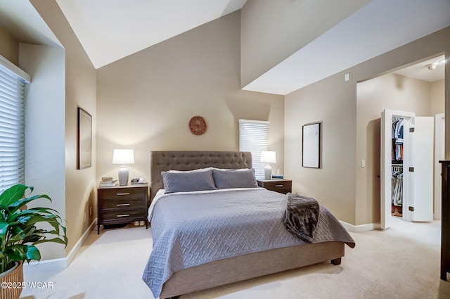 bedroom with a closet, a spacious closet, high vaulted ceiling, and light carpet