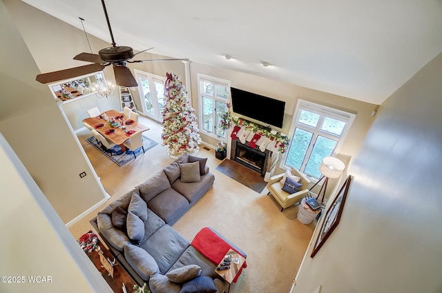 living room featuring a tile fireplace, carpet floors, ceiling fan, and high vaulted ceiling