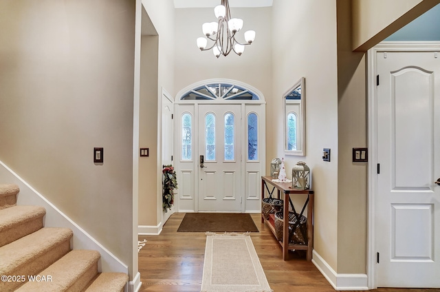 foyer entrance featuring hardwood / wood-style floors and a notable chandelier