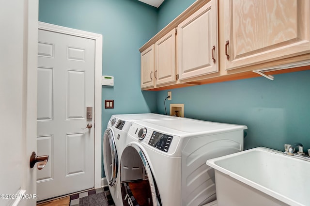 laundry area featuring sink, washing machine and dryer, and cabinets