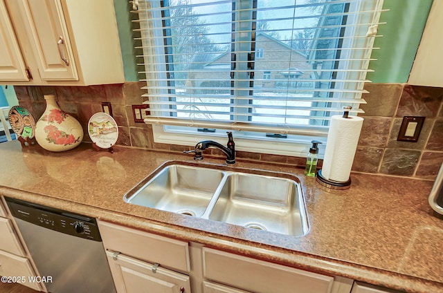 kitchen with stainless steel dishwasher, sink, and decorative backsplash