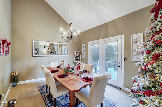 carpeted dining space with a notable chandelier and high vaulted ceiling