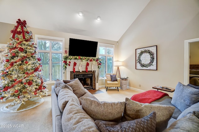 living room featuring plenty of natural light, high vaulted ceiling, and a fireplace