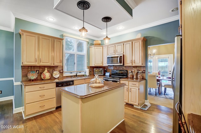 kitchen with appliances with stainless steel finishes, pendant lighting, backsplash, a center island, and light hardwood / wood-style floors