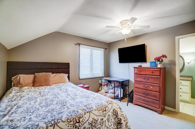 carpeted bedroom with connected bathroom, vaulted ceiling, and ceiling fan