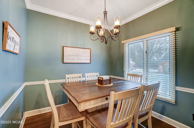 dining room with ornamental molding, wood-type flooring, and a chandelier