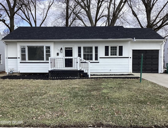 view of front of house with concrete driveway, roof with shingles, an attached garage, and a front yard