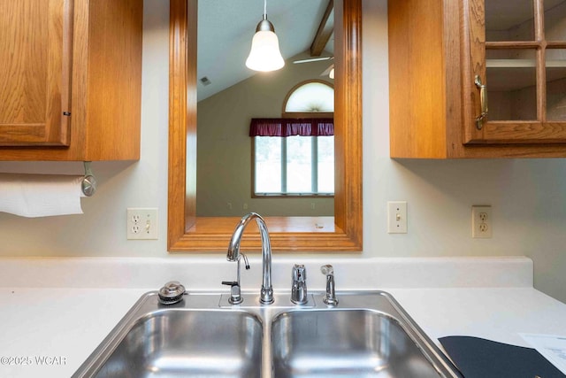 81 Riley Creek Ct, Bluffton, OH 45817 - kitchen featuring brown cabinetry, light countertops, vaulted ceiling, and hanging light fixtures