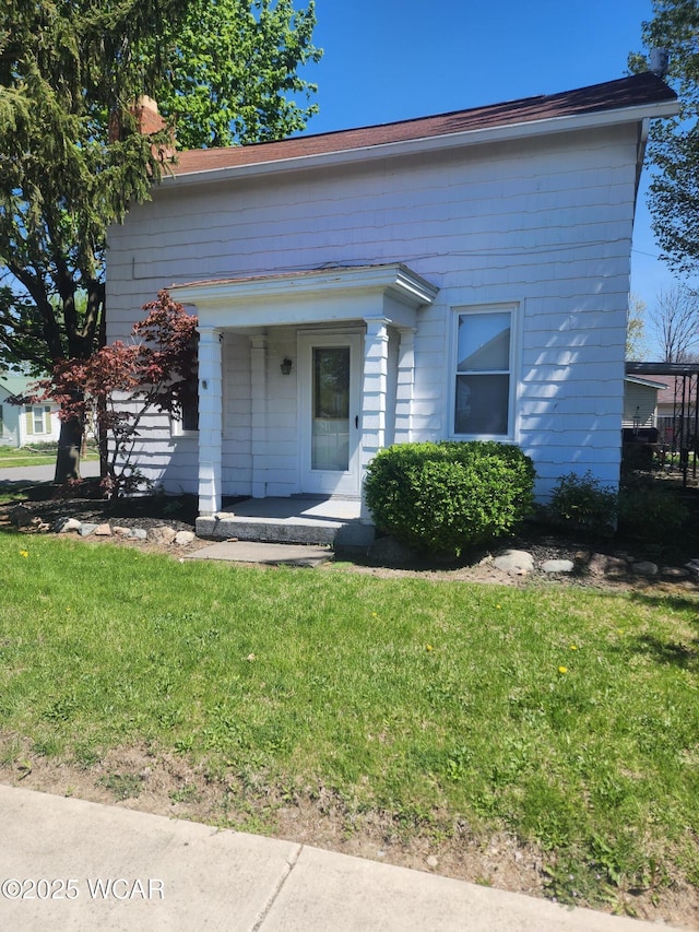 view of front facade featuring a chimney and a front lawn