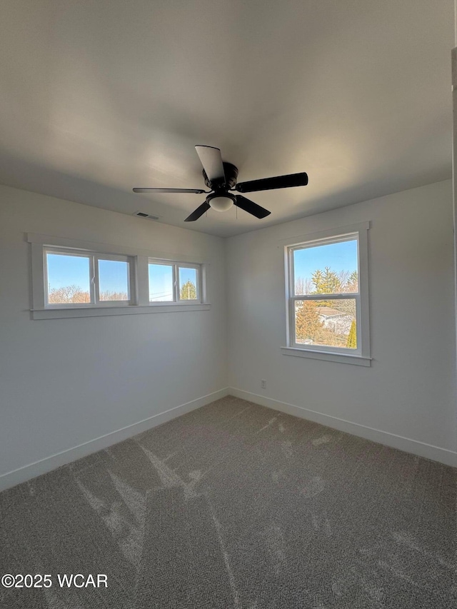 unfurnished room featuring visible vents, a healthy amount of sunlight, light colored carpet, and baseboards